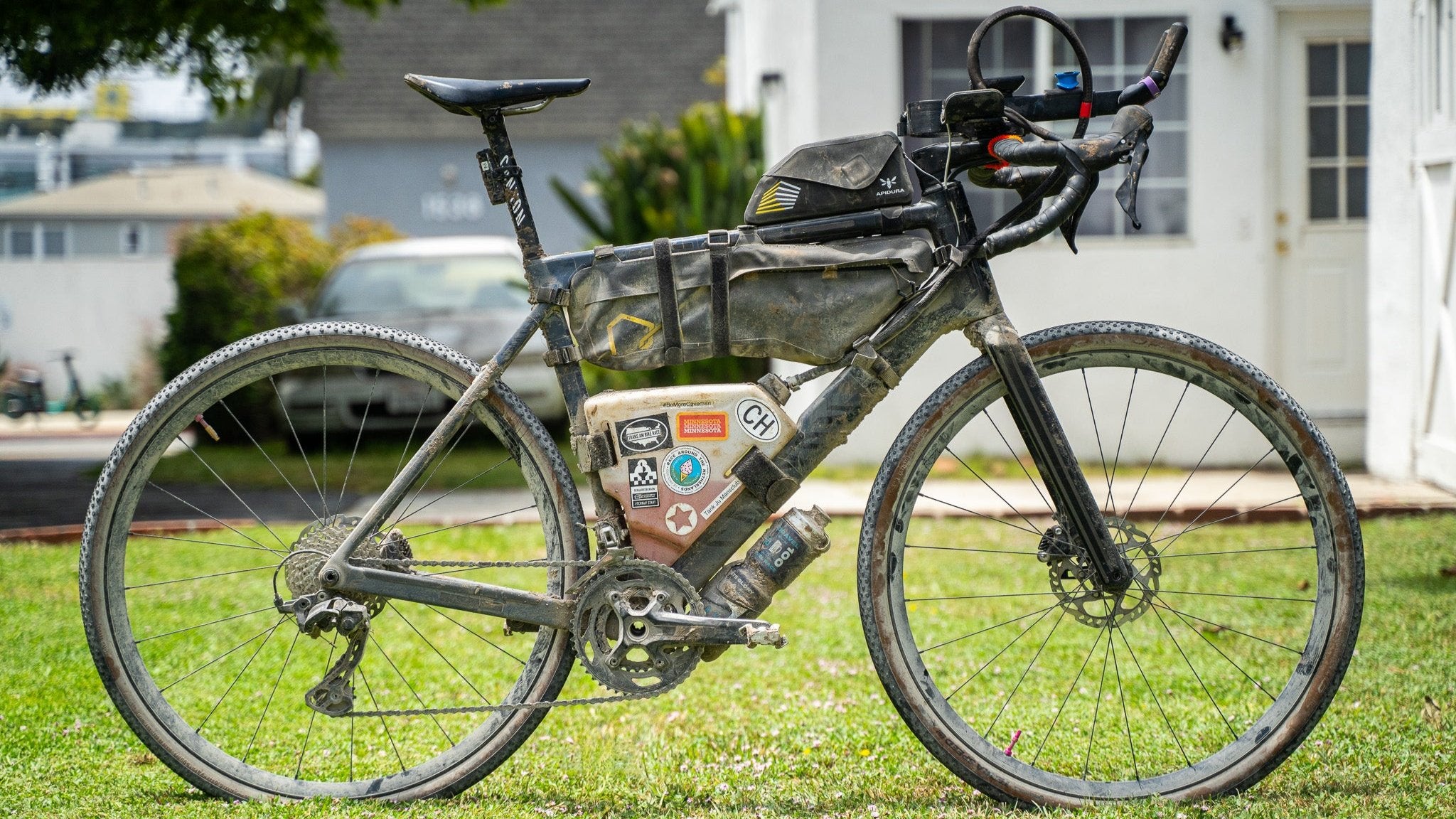 A gravel bike covered in mud, showing the CrankTank in action.